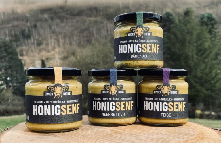 Vier Gläser Honigsenf in den Geschmacksrichtungen Pur, Meerrettich, Bärlauch und Feige vor der Natur in den Austerstücken. 