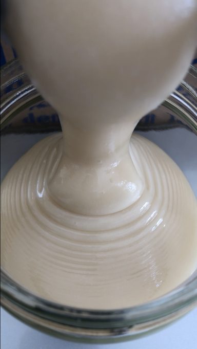 Rapshonig wird in ein Glas abgefüllt